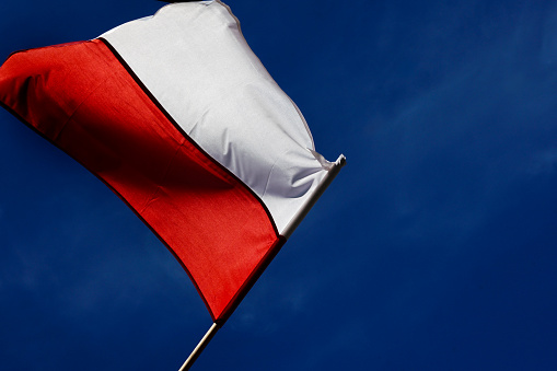 Polish flag with a blue sky as a background. Polish culture.