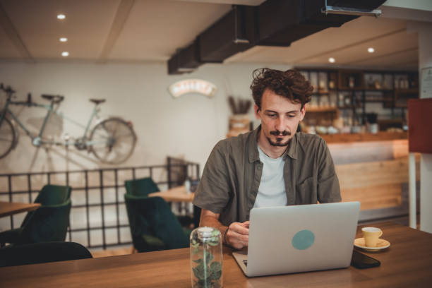istock A young freelancer works on a laptop while sitting in a cafe 1869798894