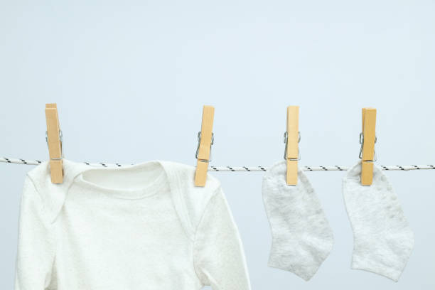 istock Child clothes hanging on twine against light background 1869807307