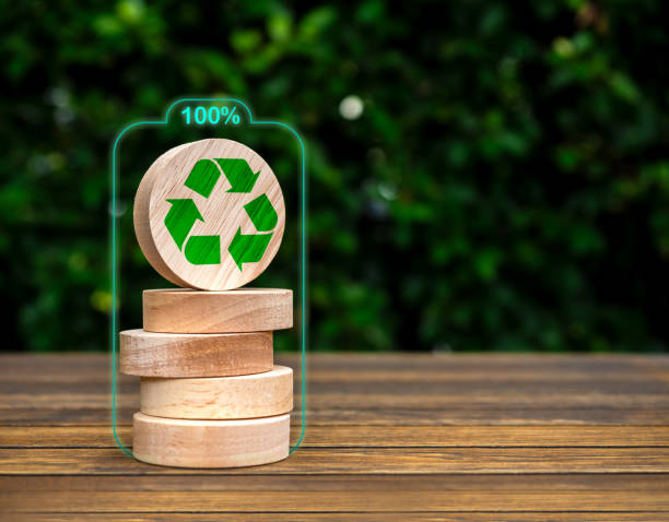 istock Renewable energy. Green recycle icon on round wooden blocks stack on green leaves background with copy space. Environmental sustainability development, Net zero carbon dioxide reduction concepts. 1869812330