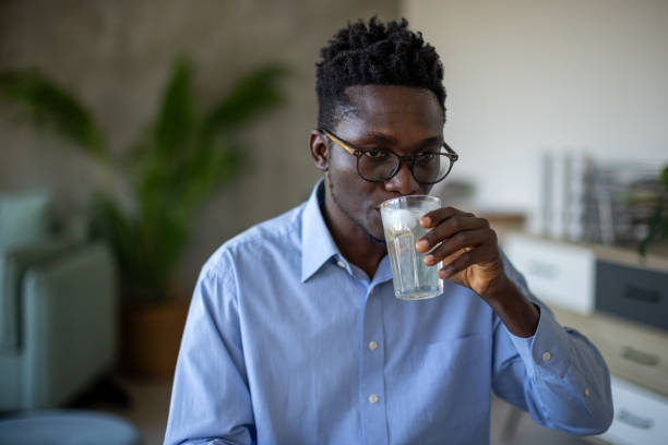 istock Young man drinking cold juice at home 1869825928