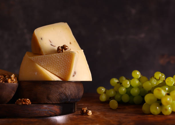 istock assorted cheeses on a wooden board with green grapes 1869829651