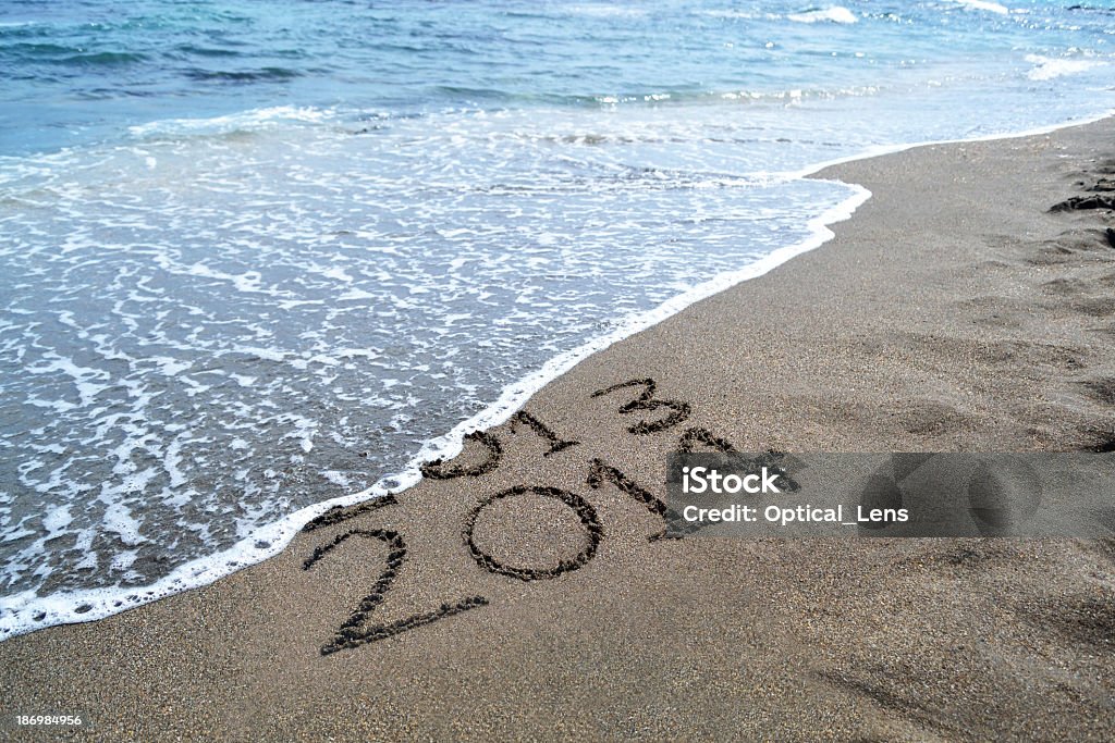 2013 2014 written in the sand, getting washed out by ocean Bringing in the New Year at the beach 2013 Stock Photo