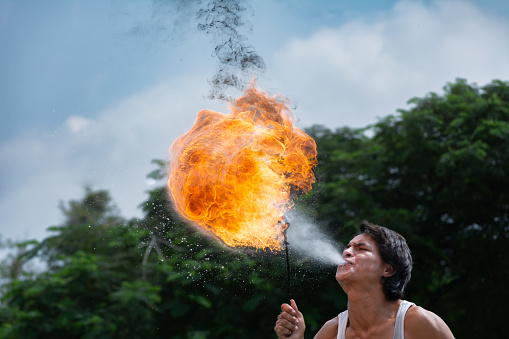 Guadalajara Jalisco Mexico - October 11, 2014: The young man on the street is spitting gasoline and produces a very large flame.