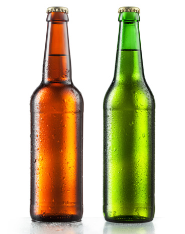 Bottles of beer with water drops on white background