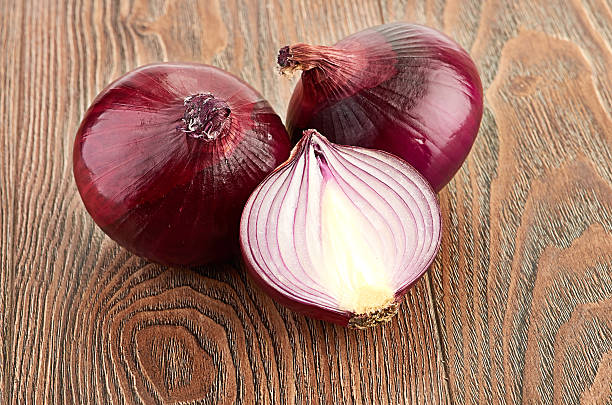 istock Fresh red onions on a wooden background 186986574