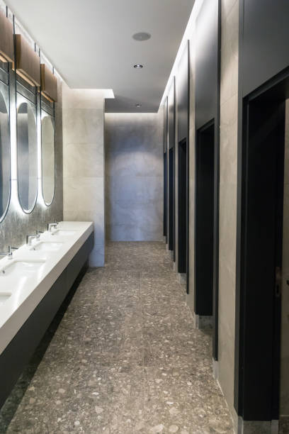 istock Stylish toilet with cubicles and illuminated oval mirrors 1869869761