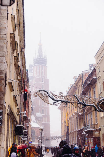Wonderful Snowy Winter Day on Old Streets of Krakow City, Poland Long exposure of heavy snowfall over the Old Town and authentic buildings decorating by Christmas decorations with crowds of people walking in Krakow, Poland, Europe long exposure winter crowd blurred motion stock pictures, royalty-free photos & images