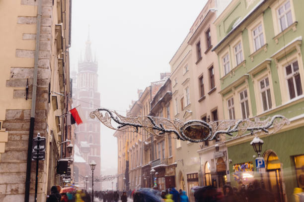 Wonderful Snowy Winter Day on Old Streets of Krakow City, Poland Long exposure of heavy snowfall over the Old Town and authentic buildings decorating by Christmas decorations with crowds of people walking in Krakow, Poland, Europe long exposure winter crowd blurred motion stock pictures, royalty-free photos & images