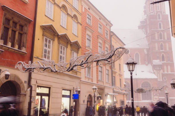 Wonderful Snowy Winter Day on Old Streets of Krakow City, Poland Long exposure of heavy snowfall over the Old Town and authentic buildings decorating by Christmas decorations with crowds of people walking in Krakow, Poland, Europe long exposure winter crowd blurred motion stock pictures, royalty-free photos & images