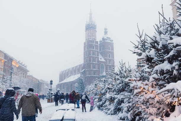 Magical Winter Day with Heavy Snowfall at Christmas Market of Krakow, Poland Long exposure dramatic view of snow blizzard over the main square of the old town of Krakow city with Christmas decorations and crowds of people long exposure winter crowd blurred motion stock pictures, royalty-free photos & images