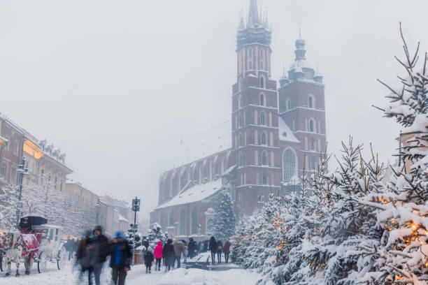 Magical Winter Day with Heavy Snowfall at Christmas Market of Krakow, Poland Long exposure dramatic view of snow blizzard over the main square of the old town of Krakow city with Christmas decorations and crowds of people long exposure winter crowd blurred motion stock pictures, royalty-free photos & images