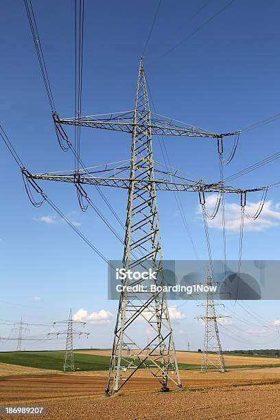 Postes De Electricidade E Linhas Em Um Campo - Fotografias de stock e mais imagens de Ao Ar Livre - Ao Ar Livre, Arame, Cabo
