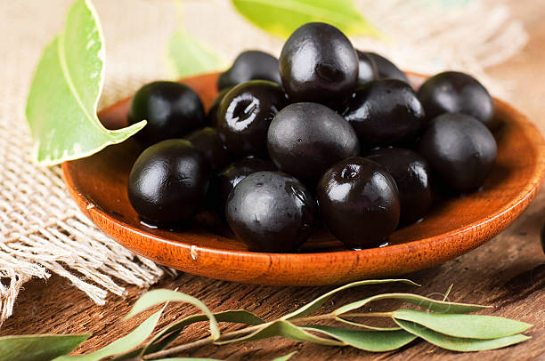 istock Black olives in a wooden plate 186989225
