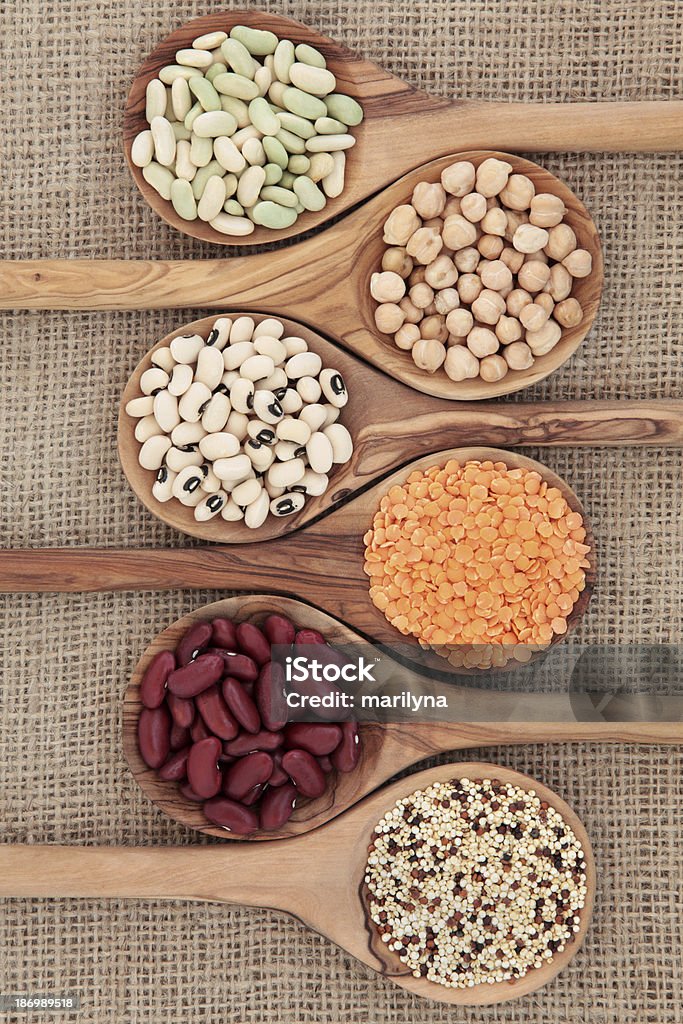 Dried Pulses Dried pulses selection in olive wood spoons over hessian background. Antioxidant Stock Photo