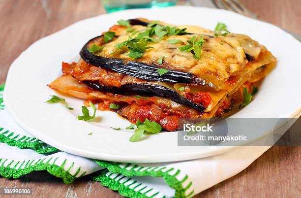 Slice Of Vegetable Lasagna On A White Plate On Wooden Table Stock Photo - Download Image Now