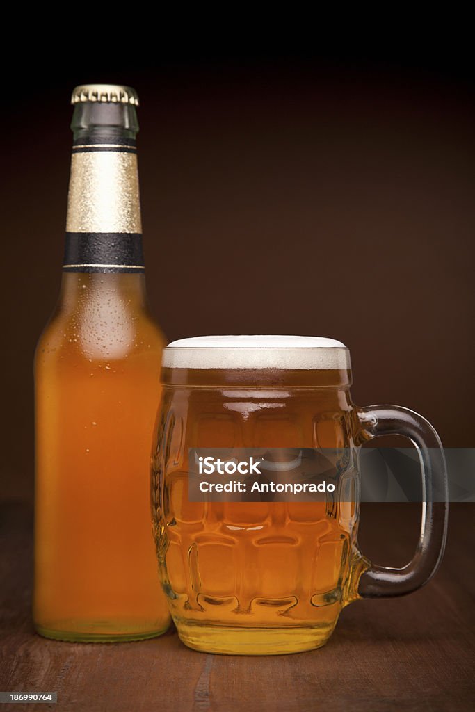 Glass and bottle of beer A glass and a bottle of beer on a wooden table. Alcohol - Drink Stock Photo