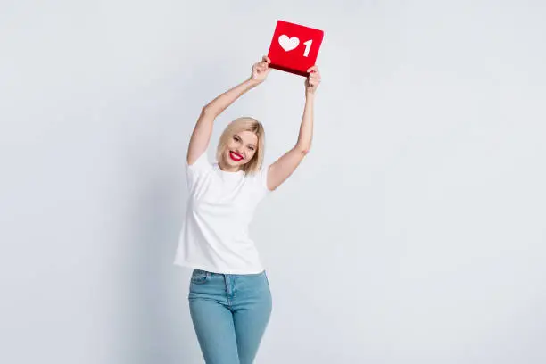 Photo of Photo of gorgeous nice woman with bob hairstyle dressed white t-shirt hold social media like over head isolated on white color background