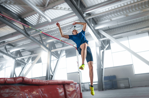 Woman in action of high jump a stadium at night. Sports banner. Horizontal copy space background