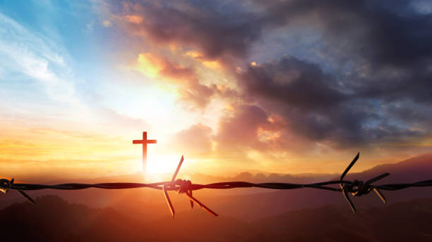 istock Cross and barbed wire against sunset over mountain landscape 3d render 1869914773