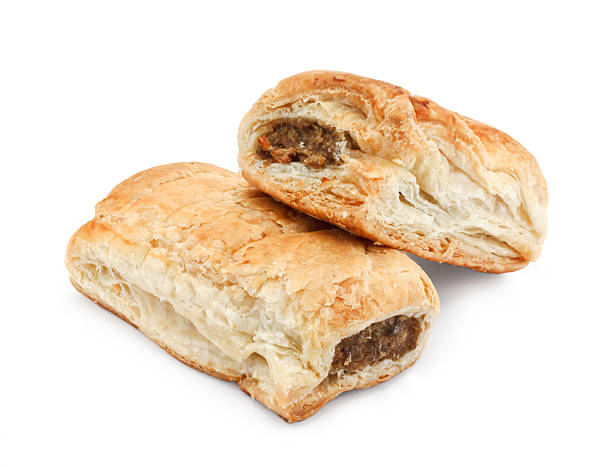 isolated sausage rolls Freshly baked pair of sausage rolls isolated against a white background a traditional popular pastry snack available hot or cold at bakeries in the UK sausage roll stock pictures, royalty-free photos & images