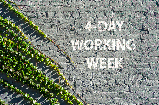 4 - Day working week on a brick wall with green leaves symbolizing nature taking over urban life.
