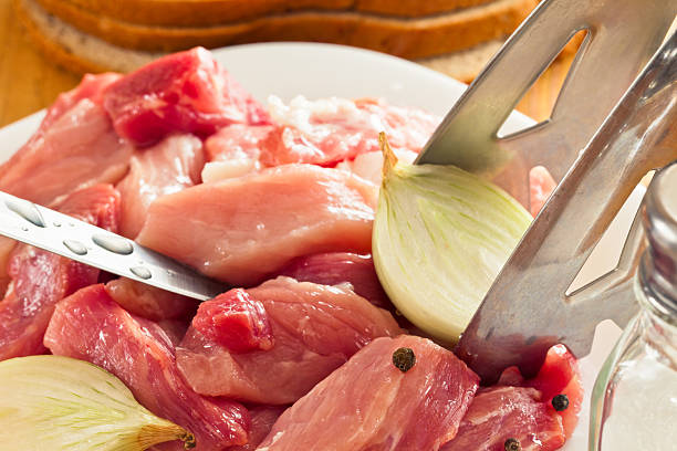 cut pieces of fresh meat with onions and peppers stock photo