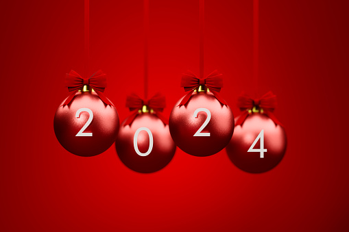 2024 written red Christmas baubles and 2024 over red background. Christmas and festivity concept. Horizontal composition with selective focus and copy space.