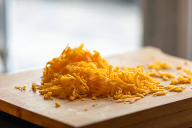 istock Shredded Cheddar Cheese on Wooden Board Close-Up 1869937467
