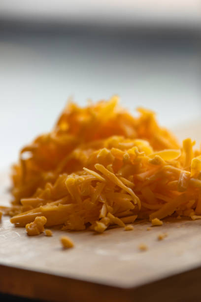 Shredded Cheddar Cheese on Wooden Board Close-Up