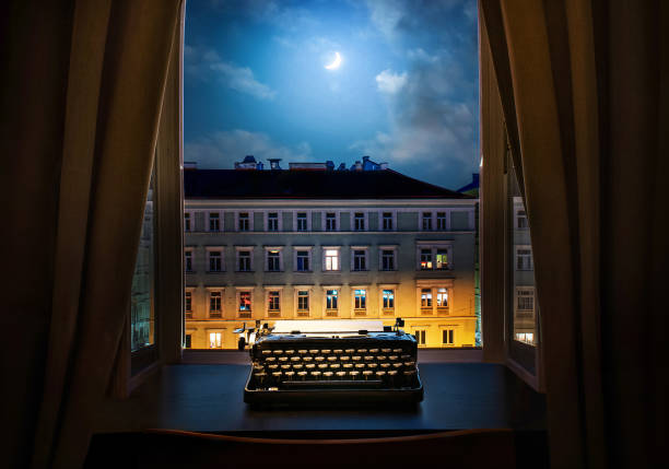 istock Workplace of a writer, journalist, creator. Old typewriter on the table against the background of ancient night city buildings. Retro style. The concept on scientific, historical, literature, education and philosophical topics. 1869942299