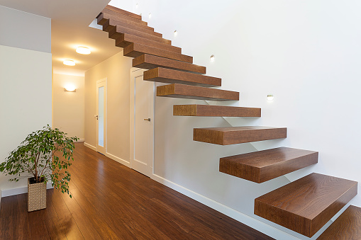 Hall way to private house and staircase to second floor. Illuminated wooden staircase.