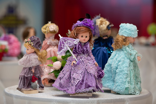 Little dolls in elegant vintage dresses. Collection of children's souvenir dolls.