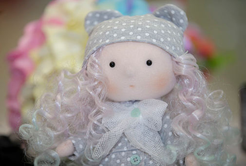 Tilda doll in the form of a girl in a gray hat.