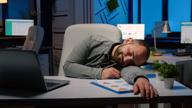 istock Exhausted overworked businessman sleeping on desk table in startup business office 1869959712