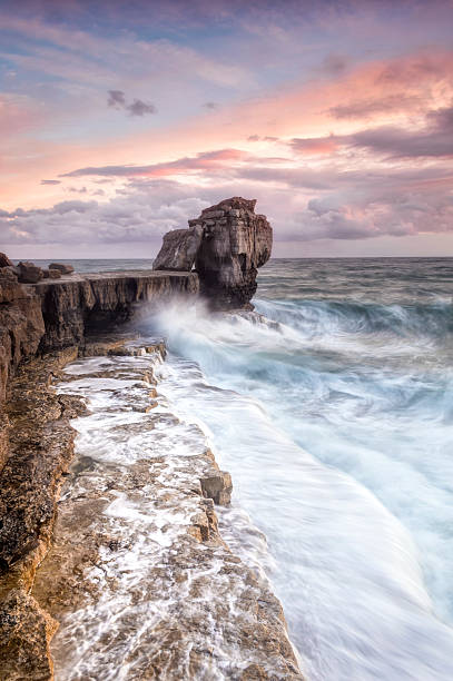 Autumn storms at Portland's Pulpit Rock A stunning autumn sunset at Pulpit rock on the Isle of Portland with the full force of the English Channel crashing against the rocks. bill of portland stock pictures, royalty-free photos & images