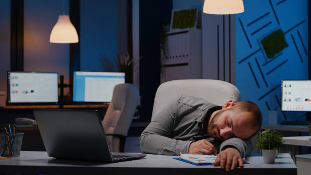 istock Exhausted overworked businessman sleeping on desk table in startup business office 1869960224