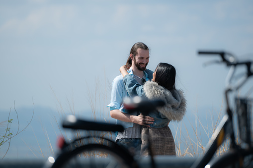 Young couple in love on the top of the mountain with bicycle foreground