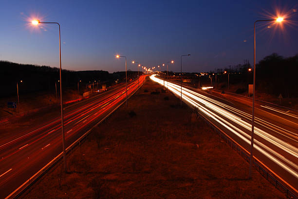 Vehicle light trails Trails of light made by vehicles travelling at night on a motorway in England UK m2 machine gun photos stock pictures, royalty-free photos & images