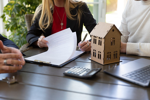 Estate agent and businessman signing sale agreement