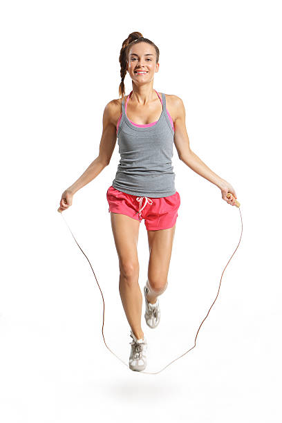 Blonde woman jumping the rope outdoors.
