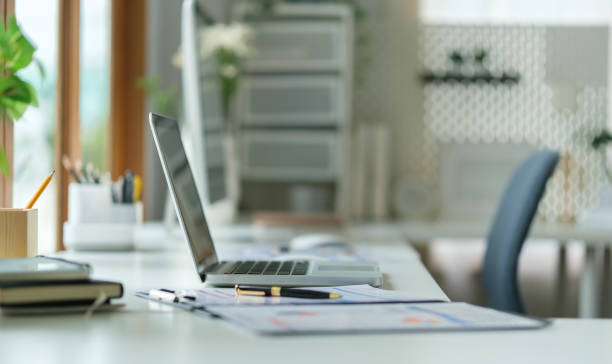 istock Modern workplace with laptop computer ,pencil holder and notebook on white table. 1869985160