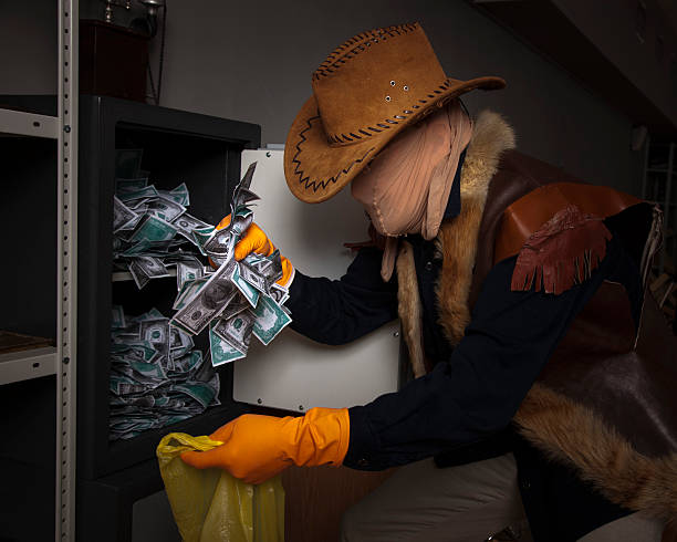 istock thief steals money from the safe 186998764