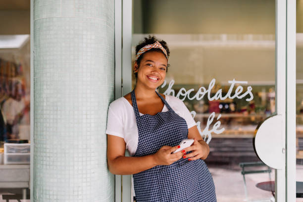 istock Cafe owner using smartphone in small business 1869989367