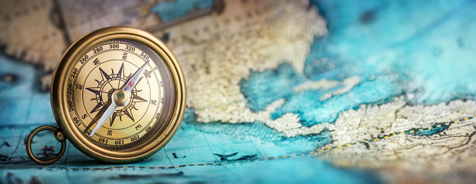 Magnetic old compass on world map.Travel, geography, navigation, tourism and exploration concept background. Macro photo. Very shallow focus.