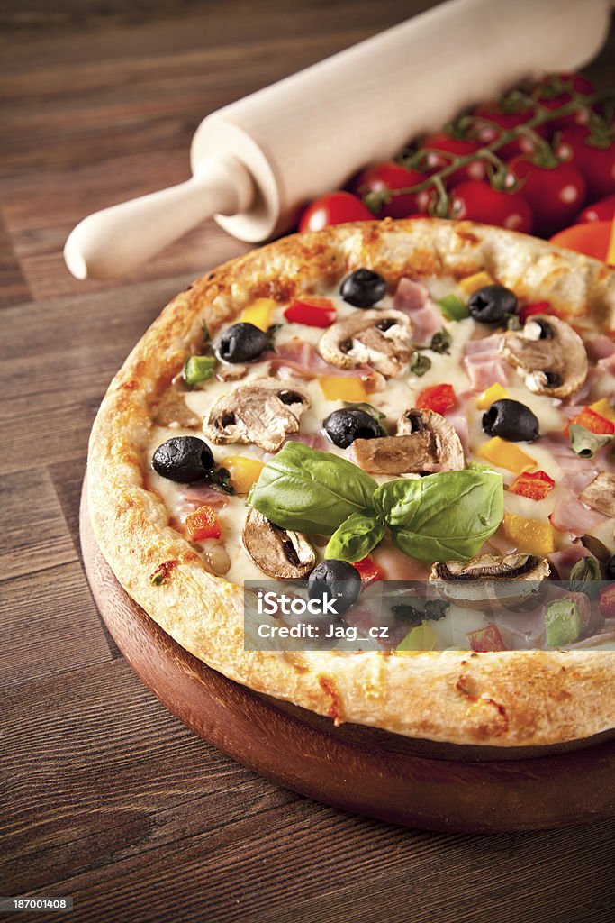 Deliziosa pizza fresca servito sul tavolo di legno - Foto stock royalty-free di Basilico