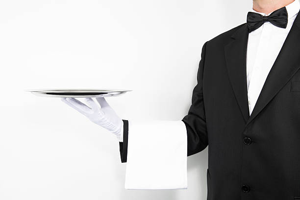istock Butler wearing white glove and napkin holding silver tray 187003444