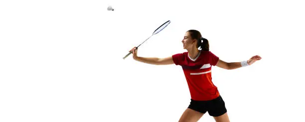 Photo of Banner. Dynamic portrait of professional badminton player practicing with intensity against pristine white background.