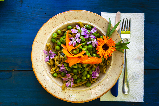 Flowers of Calendula and Malva in a Dish of Green Peas - Floral Dish Concept and Healthy Eating