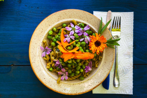 Flowers of Calendula and Malva in a Dish of Green Peas - Floral Dish Concept and Healthy Eating Flowers of Calendula and Malva in a Dish of Green Peas - Floral Dish Concept and Healthy Eating malva stock pictures, royalty-free photos & images